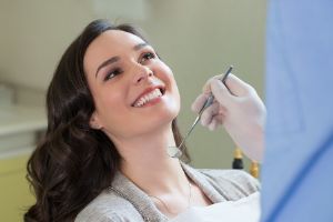 A patient shows off the results of a cosmetic whitening to the dentist.